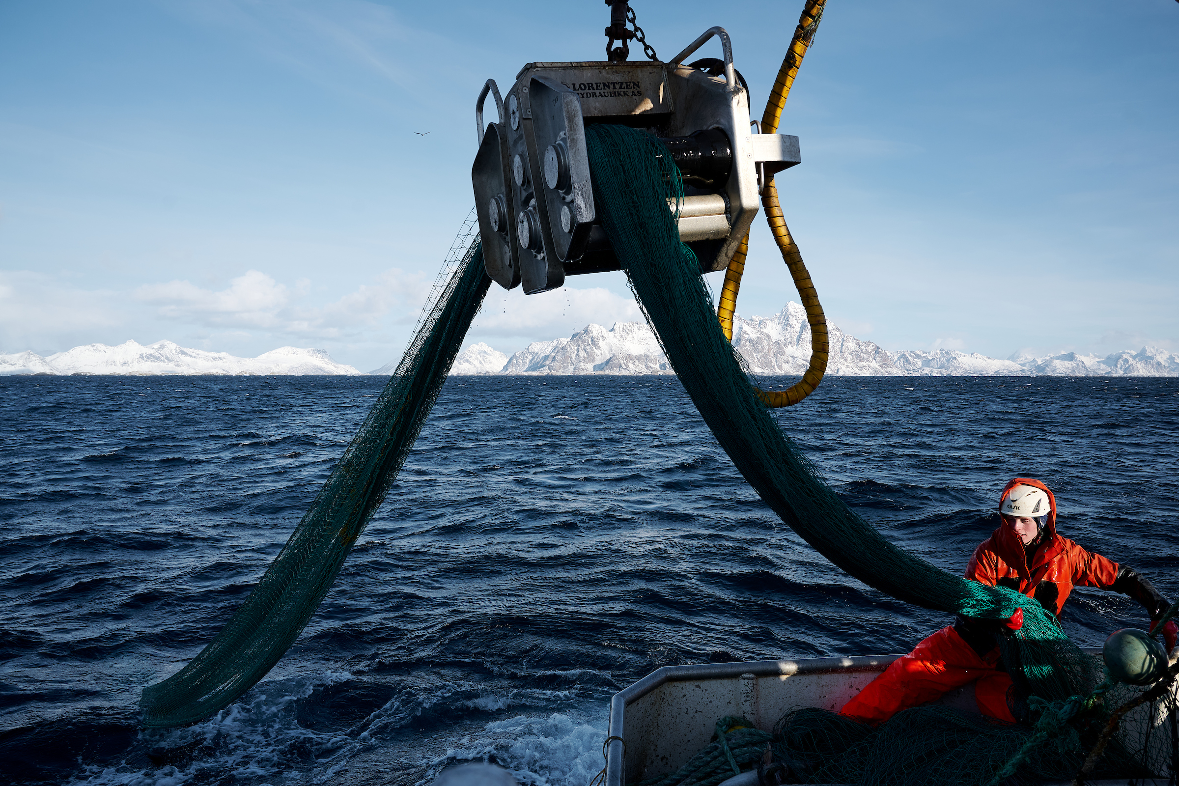 Fishing boats at sea with mountains in the background